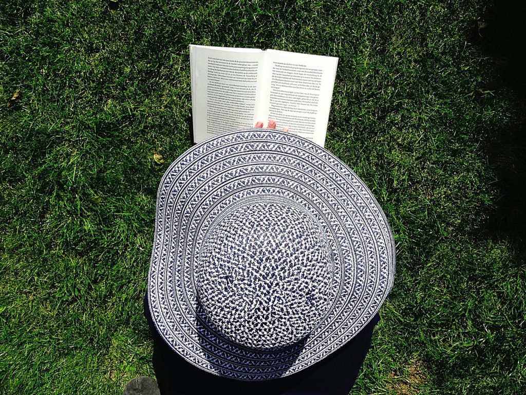 Hat and book on grass | good reading material