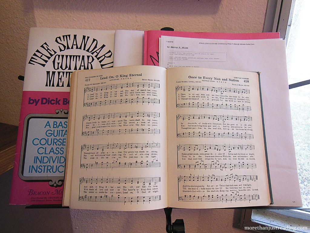 A music stand with sheet music and a hymn book