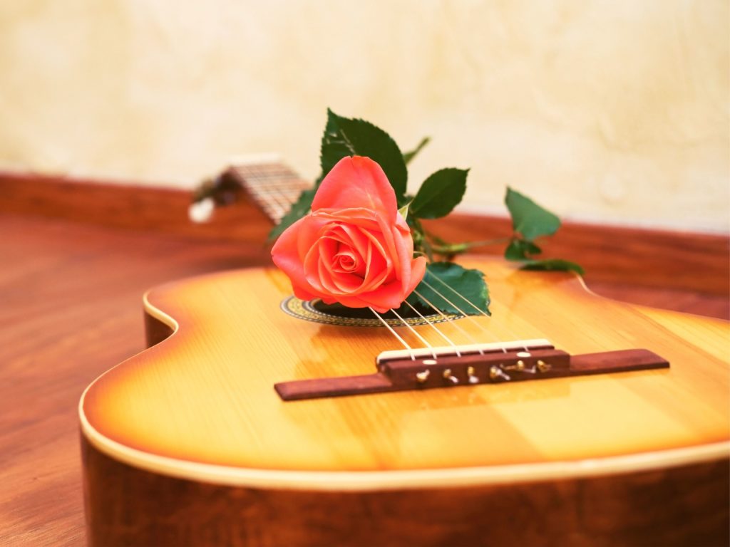 guitar with peach pink rose on it music practice tips
